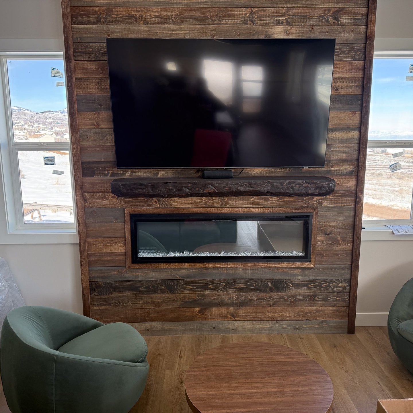 Wood fireplace feature wall around a television and linear fireplace