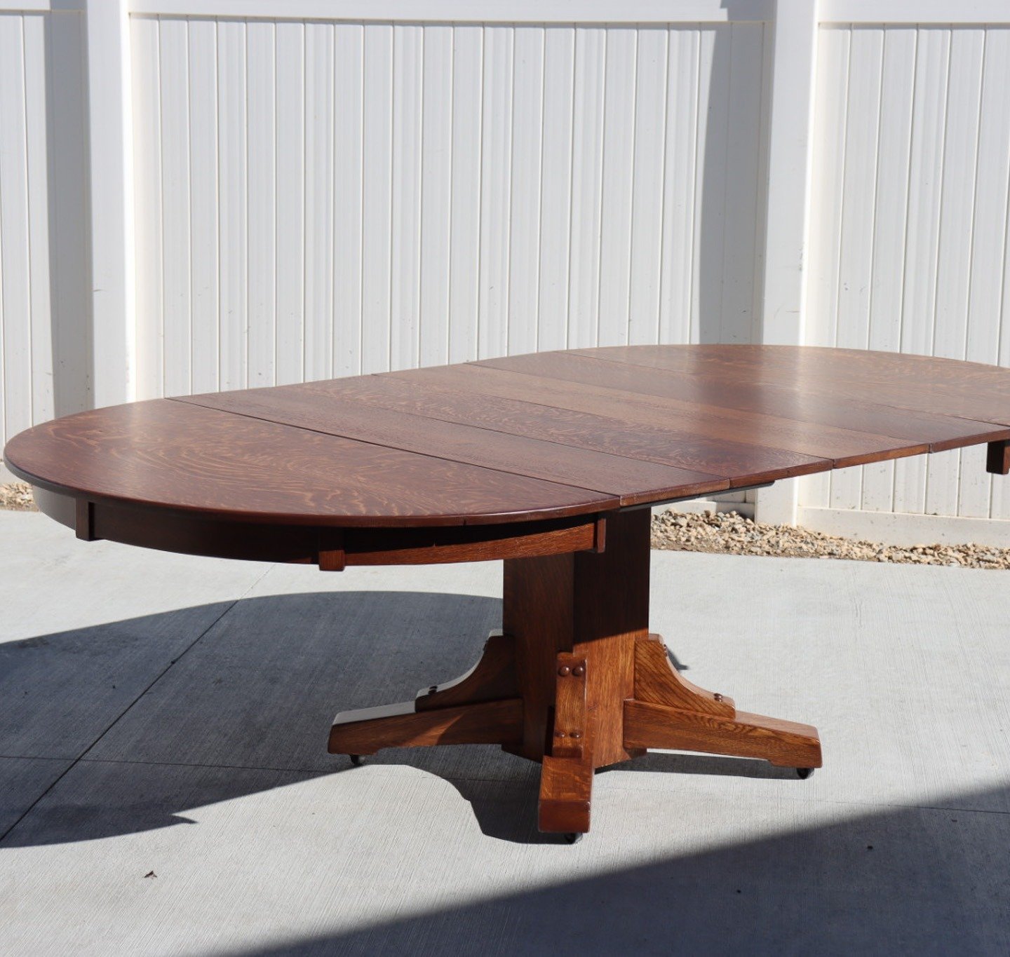 Round wood pedestal table outside after refinishing