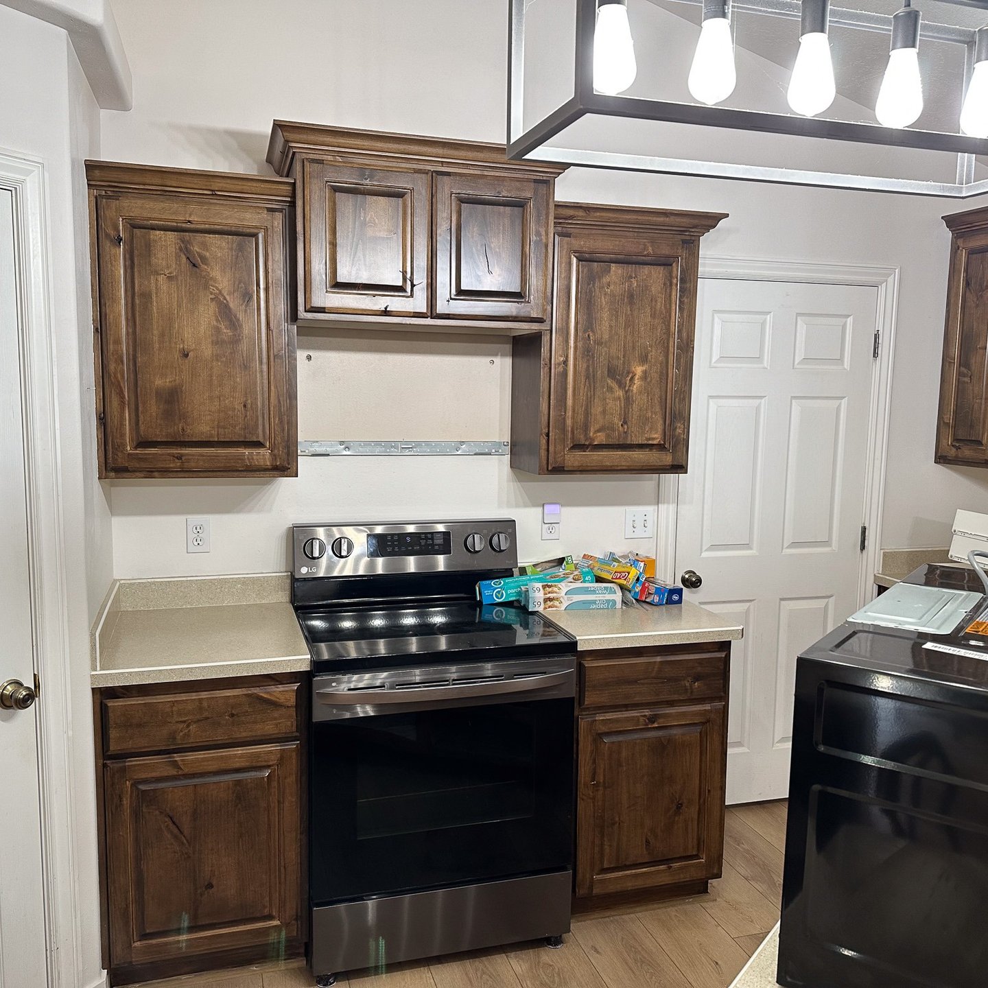 Dark stained kitchen cabinets around a stove