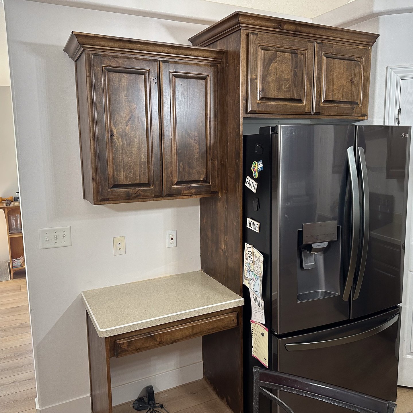 Kitchen cabinet and refrigerator surround with stained wood finish