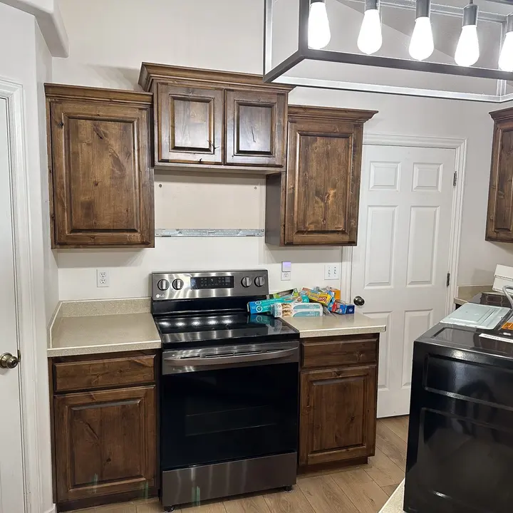 Dark stained kitchen cabinets around a stove
