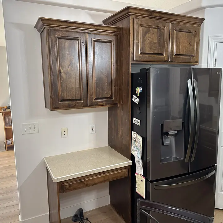 Kitchen cabinet and refrigerator surround with stained wood finish