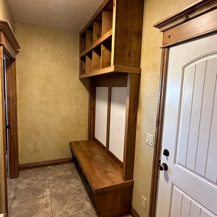 Mudroom bench and built-in storage with stained wood