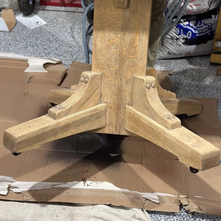 Detailed pedestal table base during refinishing